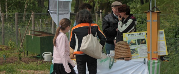 Bezoekers bekijken een informatiestand tijdens een Open Dag van de moestuinvereniging. 